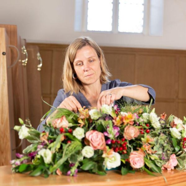 Hannah putting flowers on coffin